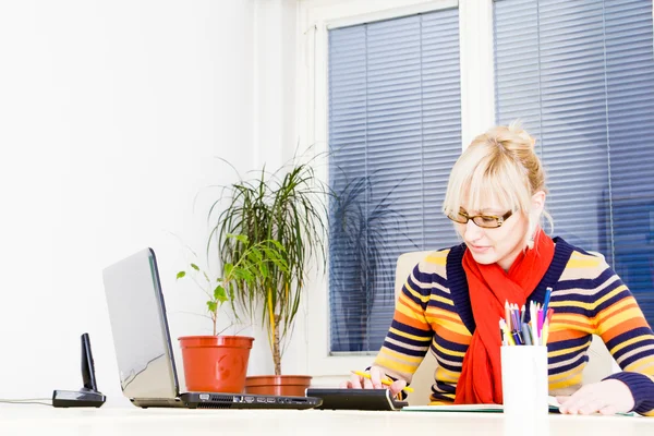 Γυναίκα ΝΕΩΝ ΕΠΙΧΕΙΡΗΜΑΤΙΩΝ χρησιμοποιώντας φορητό υπολογιστή στην επιφάνεια εργασίας — Φωτογραφία Αρχείου