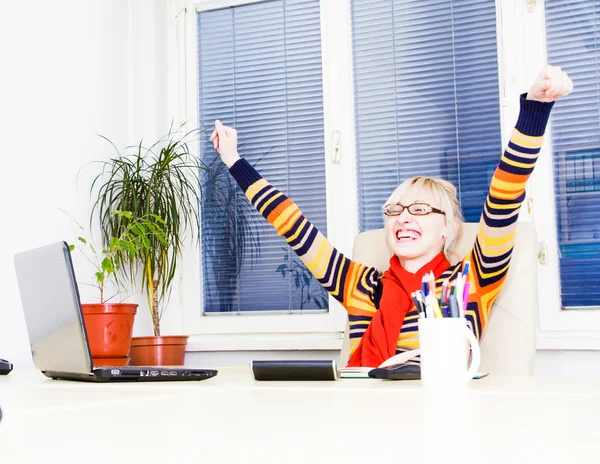 Ung framgångsrik kvinna sitter vid sitt skrivbord på kontoret — Stockfoto