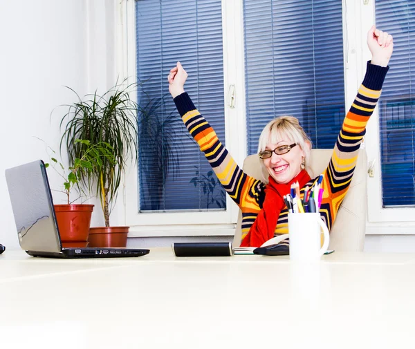 Ung framgångsrik kvinna sitter vid sitt skrivbord på kontoret — Stockfoto