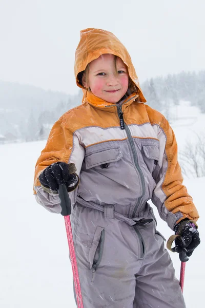 Petite fille avec des skis dans la montagne enneigée — Photo