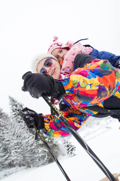 Jovem mãe passar um tempo de inverno com seu pequeno doughter — Fotografia de Stock