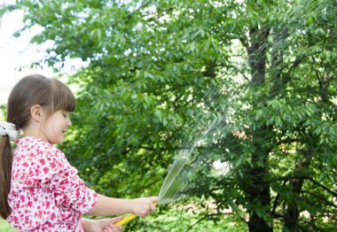 küçük kız hortum ve su ile oynama