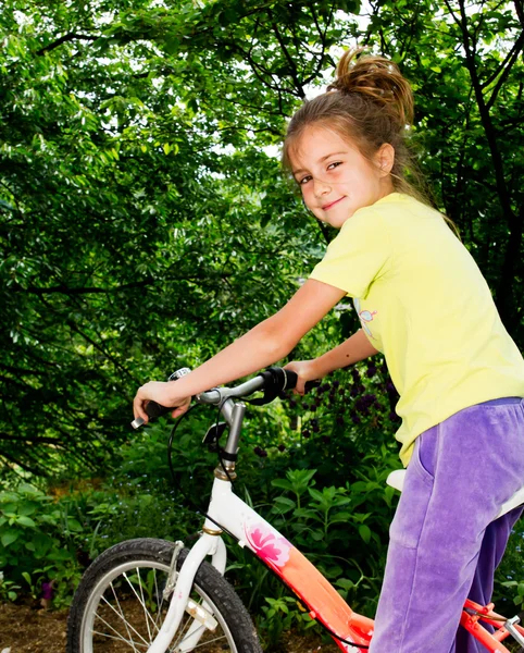 Güzel küçük bir kız bir bisiklet üzerinde — Stok fotoğraf