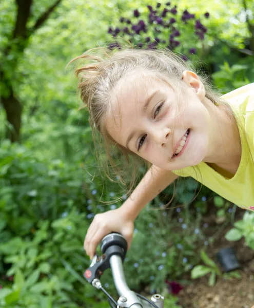 Güzel küçük bir kız bir bisiklet üzerinde — Stok fotoğraf