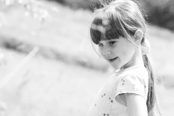 Маленькая девочка стоит в траве — стоковое фото