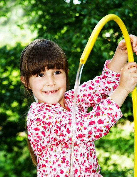 Little girl playing with hose and water — Stock Photo, Image