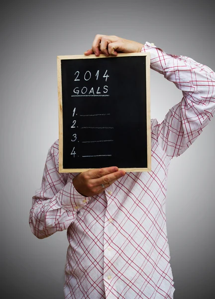 Businessman hiding behind the new year 2014. Board with goals i — Stock Photo, Image