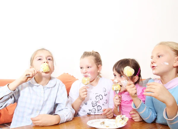 Grupo de niños comiendo pastel juntos y sonriendo —  Fotos de Stock