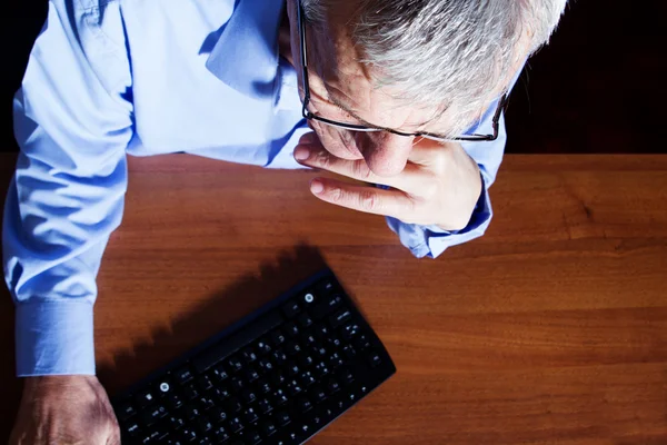 Verticale weergave van een senior zakenman werken met tastature — Stockfoto