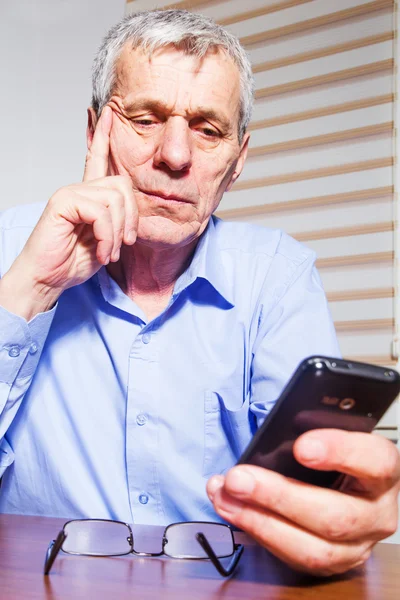 Starszy biznesmen korzystania z telefonu w jego biurze — Zdjęcie stockowe