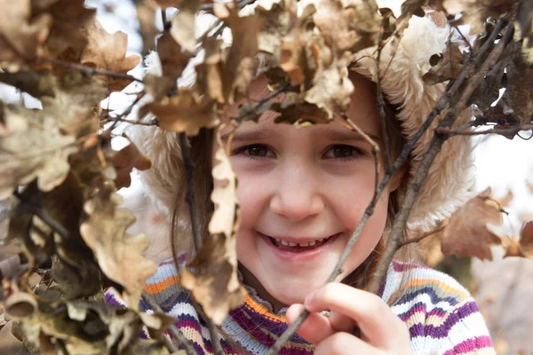 Liten flicka stående i höst skog — Stockfoto