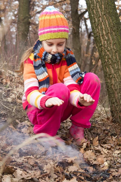 Liten flicka belysning eld i skogen - farliga spelar — Stockfoto