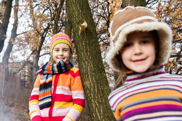 Zwei kleine Schwestermädchen umarmen sich beim Spielen im Wald — Stockfoto