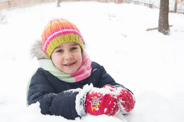 Kleines Mädchen liegt auf dem Schnee — Stockfoto