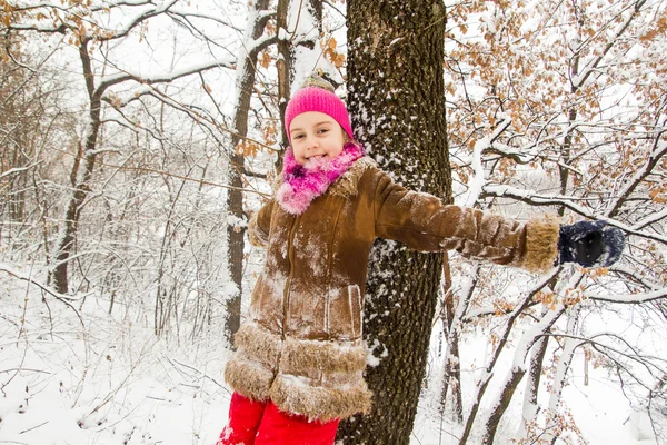 Glad liten flicka tillbringa en trevlig tid i vinter skog — Stockfoto