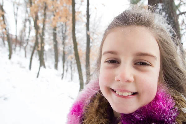 Mooi klein meisje met sneeuw in haar lange haren — Stockfoto