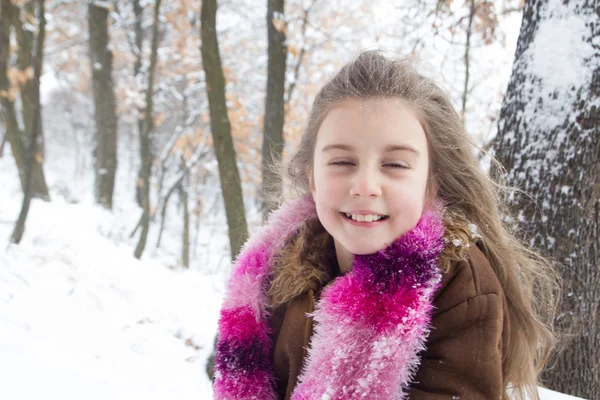 Flot lille pige med sne i sit lange hår - Stock-foto