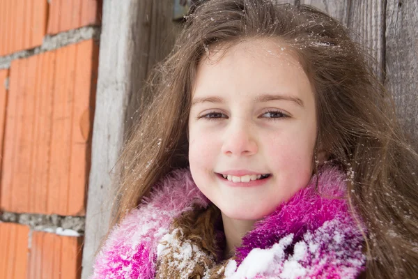 Hübsches kleines Mädchen mit Schnee in ihren langen Haaren — Stockfoto