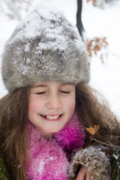 Счастливая маленькая девочка в теплой зимней шляпе — стоковое фото