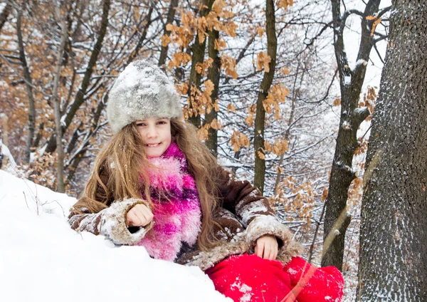 Glückliches kleines Mädchen, das eine schöne Zeit im Winterwald verbringt — Stockfoto