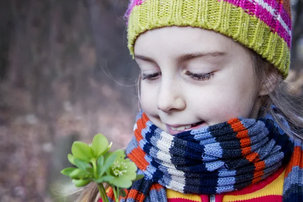 Pretty little girl holding helleborus flower - Spring is here — Stock Photo, Image
