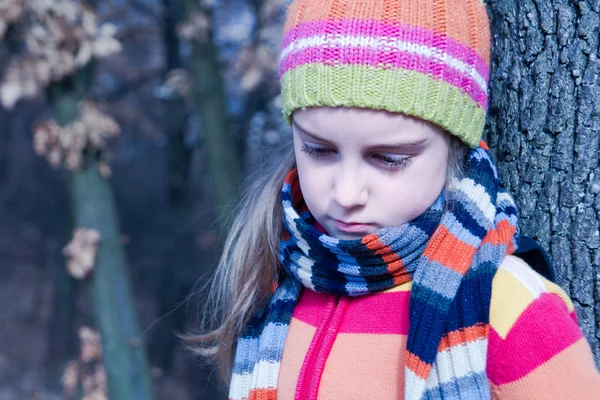 Sad little girl in the autumn park — Stock Photo, Image