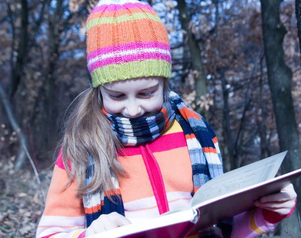 Kleines asiatisches Kind liest draußen ein Buch — Stockfoto