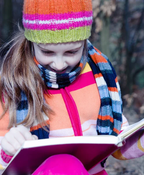 Lilla asiatiska barn läser en bok utomhus — Stockfoto