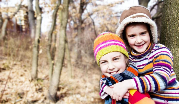 2 つのリトル シスター女の子抱擁と森で遊ぶ — ストック写真