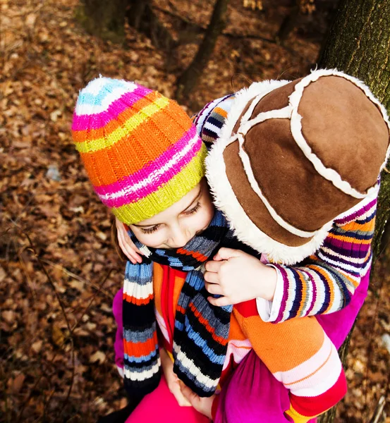 Two little sister girls hug playing in the forest — Stock Photo, Image