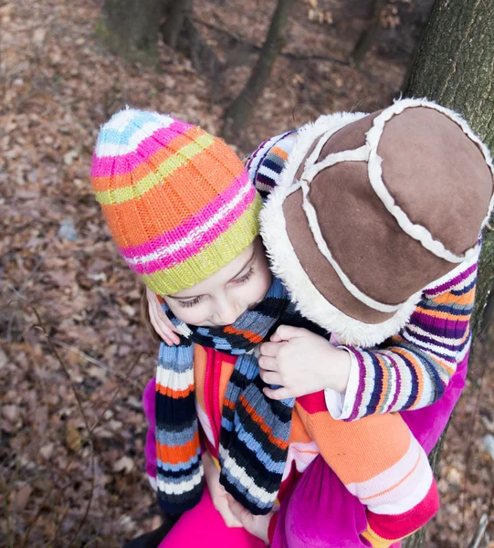 Two little sister girls hug playing in the forest — Stock Photo, Image