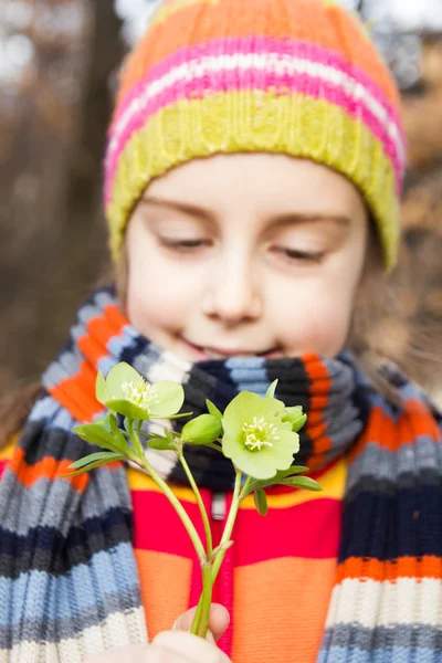 Niña bonita sosteniendo flor de helleborus - La primavera está aquí —  Fotos de Stock