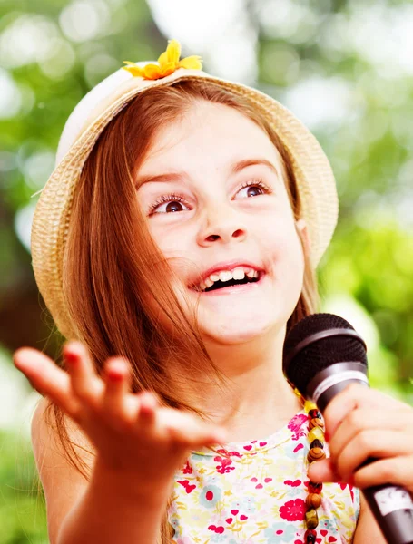 Hübsches kleines Mädchen mit dem Mikrofon in der Hand - im Freien — Stockfoto
