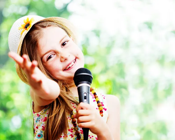 Hübsches kleines Mädchen mit dem Mikrofon in der Hand - im Freien — Stockfoto
