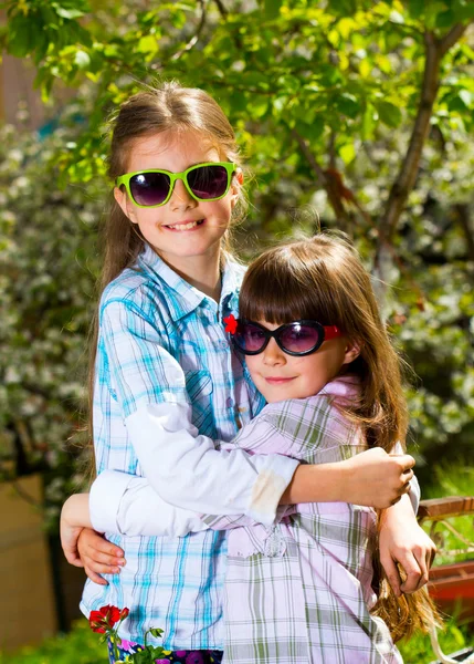 Deux petites sœurs en lunettes de soleil posant en plein air — Photo