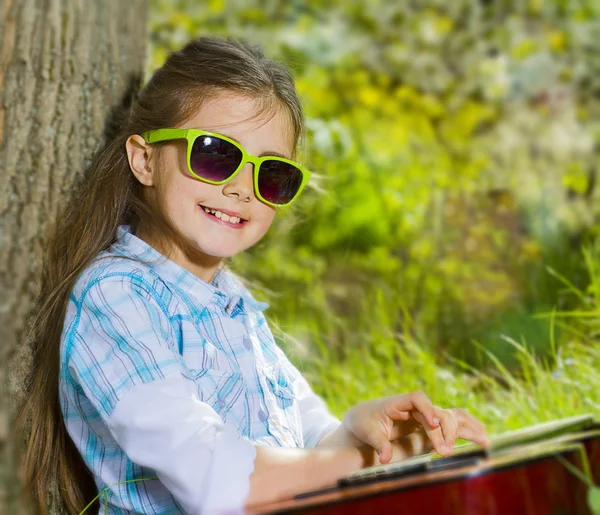 Mooi klein meisje een gitaar spelen. lentetijd — Stockfoto