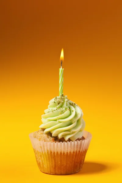 Cupcake with candle isolated on orange background — Stock Photo, Image