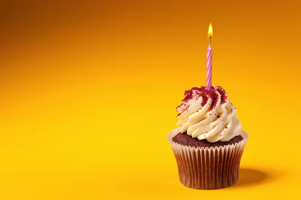 Bizcocho de chocolate con vela aislado sobre fondo naranja con — Stok fotoğraf