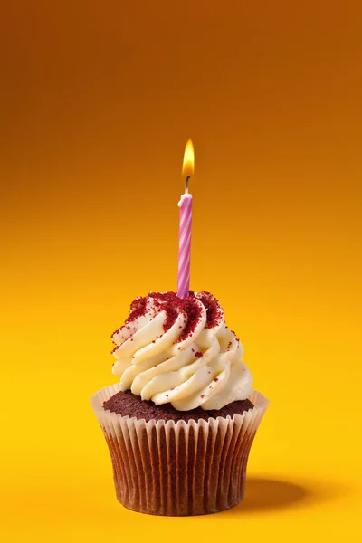 Σοκολάτα cupcake με κερί που απομονώνονται σε πορτοκαλί φόντο — Φωτογραφία Αρχείου