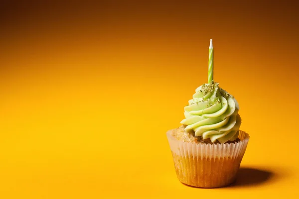 Cupcake with candle isolated on orange background — Stock Photo, Image