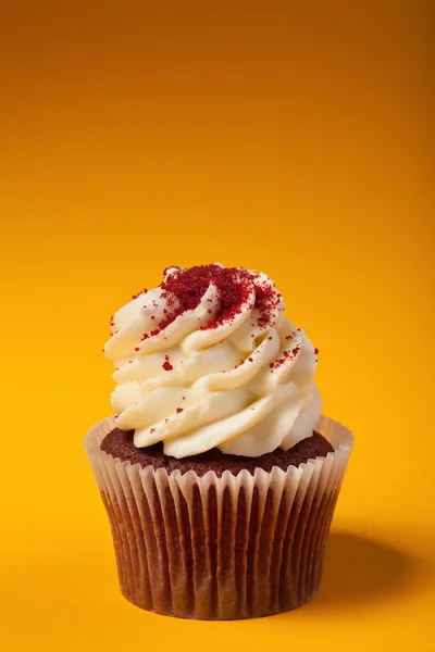 Magdalena de chocolate con crema aislada sobre fondo naranja con — Foto de Stock