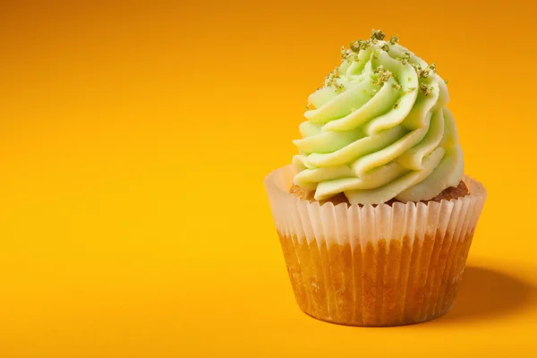 Cupcake with cream isolated on orange background with copyspace — Stock Photo, Image