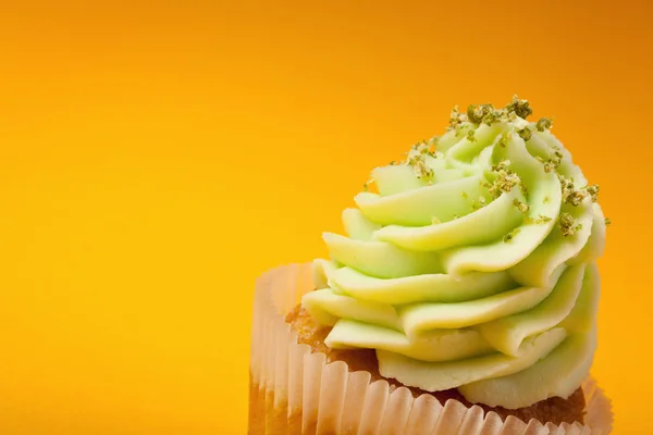 Cupcake with cream isolated on orange background with copyspace — Stock Photo, Image