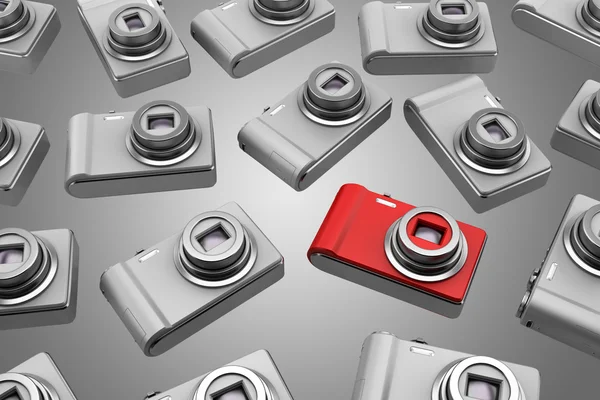 Red point and shoot photo camera among gray similar isolated on — Stock Photo, Image