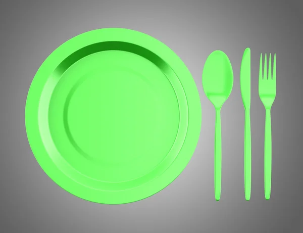 Piatto verde vuoto con coltello, forchetta e cucchiaio isolato su ba grigia — Foto Stock