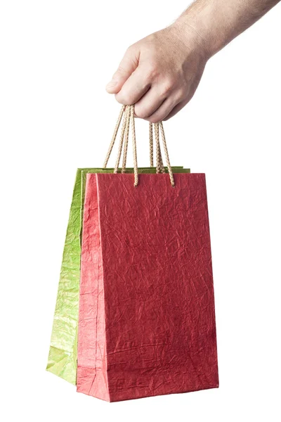 Mão masculina segurando dois sacos de compras isolados no fundo branco — Fotografia de Stock