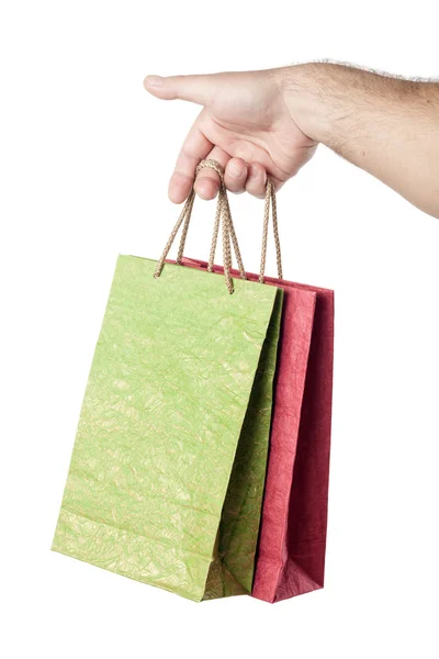 Mão masculina segurando dois sacos de compras isolados no fundo branco — Fotografia de Stock