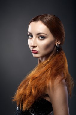 beautiful young redhead woman isolated on dark background