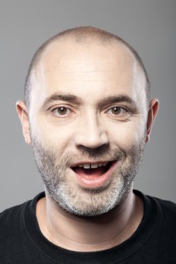 gri arka plan üzerinde izole ironik gülümseyen adam portresi
