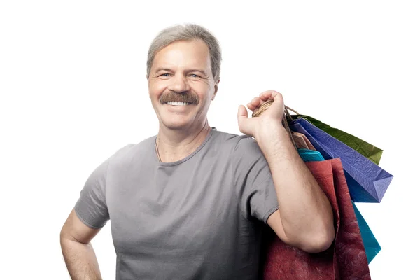 Smiling mature man holding shopping bags isolated on white backg — Stock Photo, Image